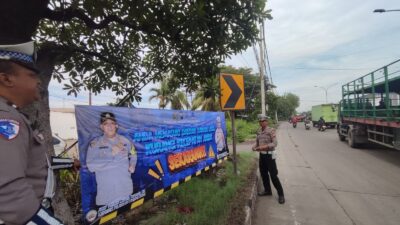 Pasang Spanduk Besar Jelang Nataru, Satlantas Polres Tanjung Perak Himbau Kurangi Kecepatan